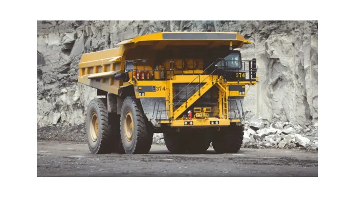 Image and front view of a Large yellow dumper truck driving in a quarry