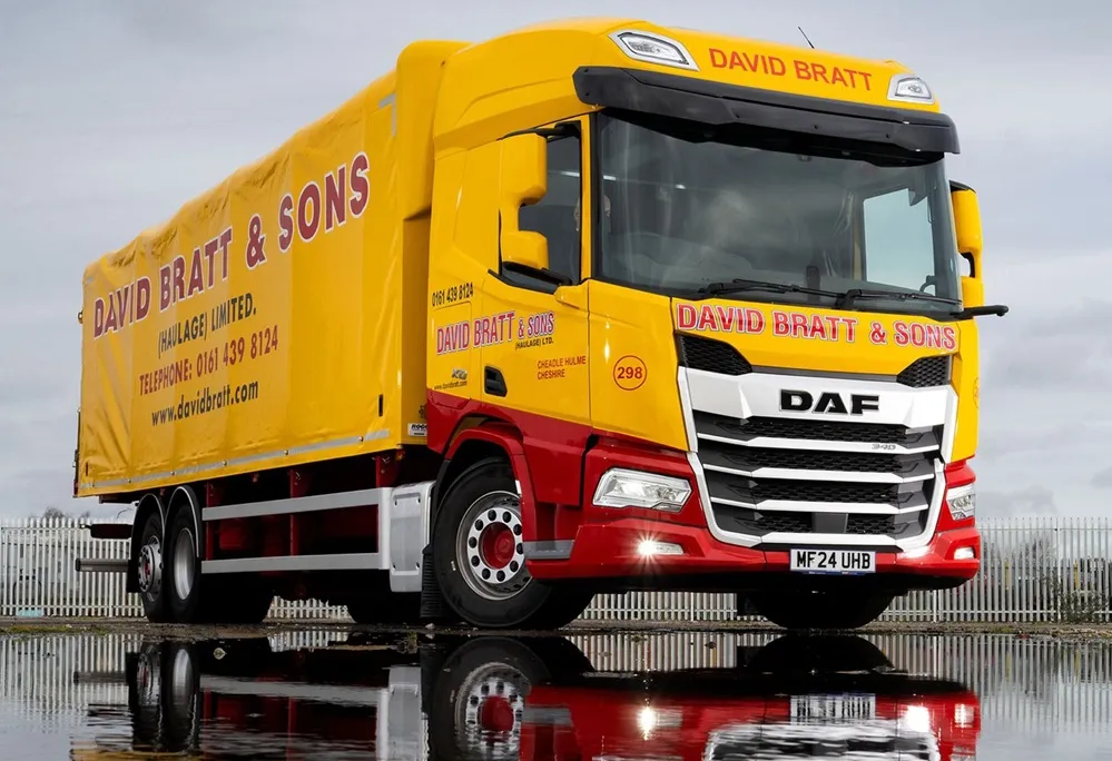 David Bratt and Sons Yellow Lorry pn wet tarmac causing a reflection