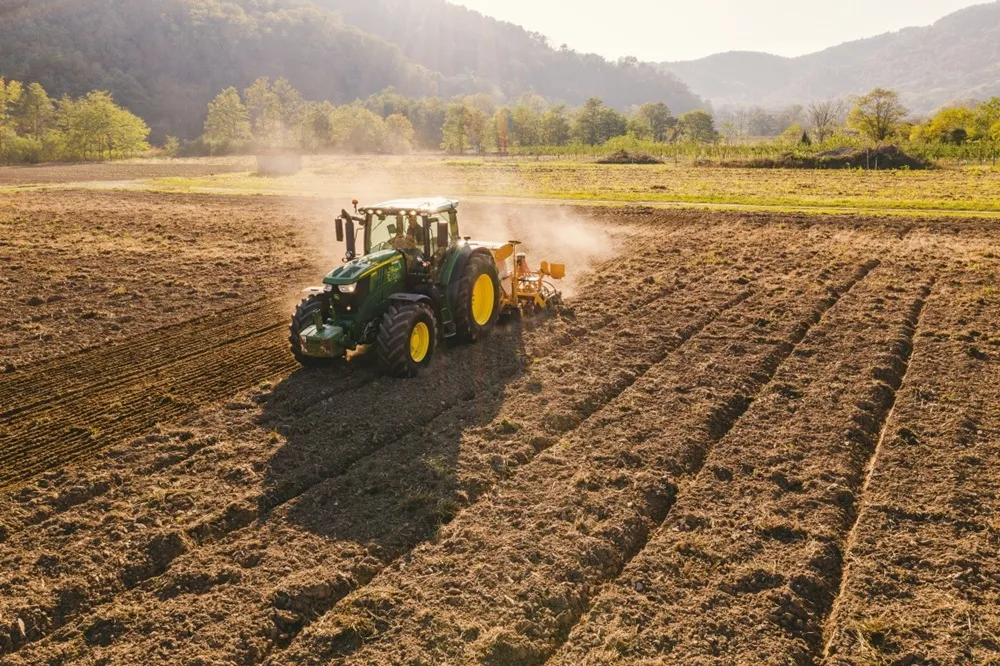 Image of a green tractor plowing a field